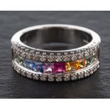 An 18ct white gold ring set with vari-coloured, mixed-cut coloured sapphires,: some synthetic,