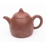 A small Yixing stoneware teapot and cover: the bullet shaped body of chocolate hue with sandy