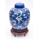 A Chinese porcelain jar and cover: of oviform with domed cover, painted in blue with prunus,