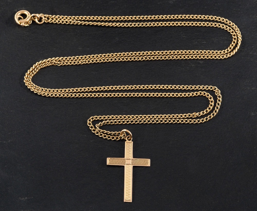 An engine turned cross pendant,: stamped '9CT', length ca. 2.