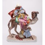 A large Royal Dux Bohemia porcelain group: modelled as an Arab atop a camel with a young lad with