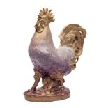 A large Continental porcelain figure: of a crowing cockerel on an oval rustic base,