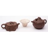 A Chinese Dehua blanc de Chine libation cup and two Yixing teapots and covers: the cup of