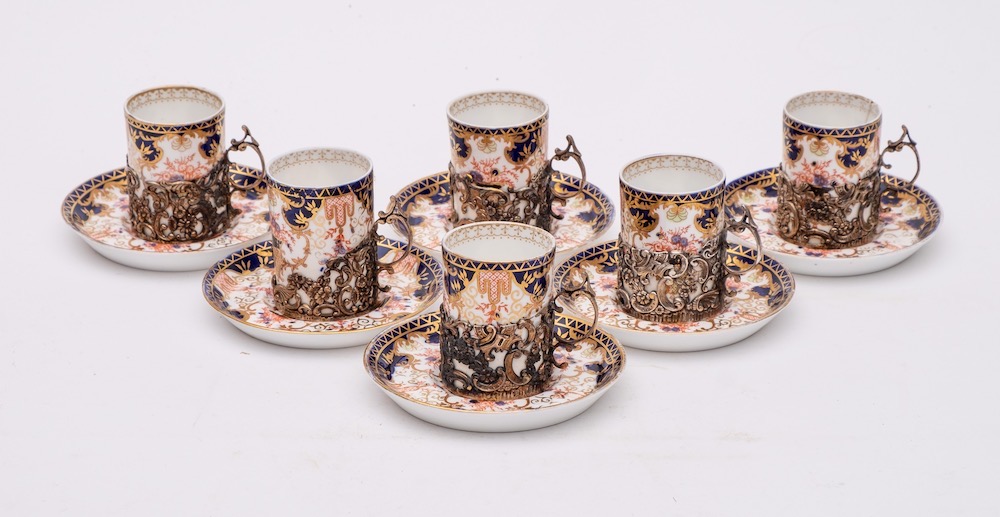 A set of six Royal Crown Derby silver-mounted porcelain coffee cans and saucers: decorated in an