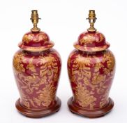 A pair of modern ceramic table lamps: decorated with scrolling flowers and foliage on a claret