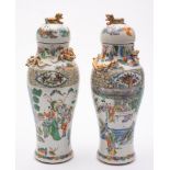 A pair of Chinese famille verte vases and covers: of baluster form with domed covers and lion-dog