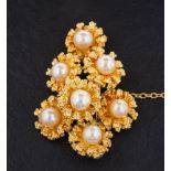 An 18ct gold and cultured pearl brooch in the form of a spray of flowers,