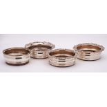 A pair of silver plated wine coasters: of circular outline with foliate borders,
