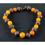 A carved seed pod and amber bead necklace and a Scottish carnelian and jasper bracelet,