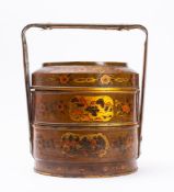 A Chinese lacquered and painted three-division food container: decorated with flowers and