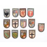 A collection of Third Reich period Winter Helpers Wappen Badges: various towns and districts.