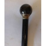 An ebonised and silver mounted walking cane; marks for Henry Howell & Co Ltd, London,