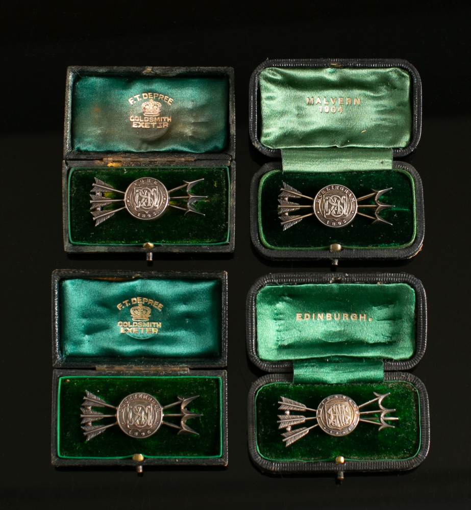 Four Victorian white metal Archery trophy brooches: each in the form of a monogrammed target