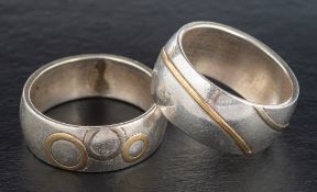 Two silver rings with applied, abstract patterns,: stamped with maker's mark 'OCS',