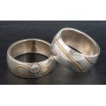 Two silver rings with applied, abstract patterns,: stamped with maker's mark 'OCS',