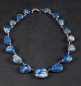 A graduated lapis lazuli pebble mounted necklace: with spectacle frame settings, length ca.