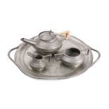 An Arts & Craft influence pewter three-piece tea service: together with circular serving tray with