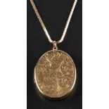 A 9ct gold oval locket pendant with engraved foliate decoration,: with hallmarks for Birmingham,