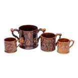 A large 19th century treacle-glazed frog loving-cup and three similar mugs: the exteriors with