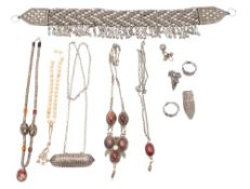 A collection of Middle Eastern silver jewellery: includes a pale stone bead bracelet, four rings,
