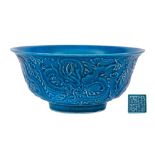 A Chinese blue ground 'Dragon' bowl: the exterior decorated in relief with three scally dragons