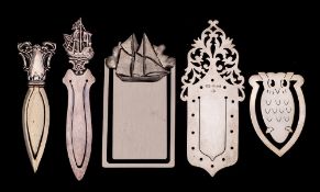 A collection of four assorted silver book marks,