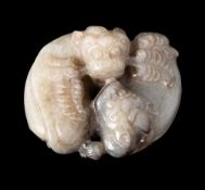 A Chinese jade carving: of two reclining mythical beasts, one holding leafy sprays in its mouth,