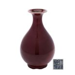 A Chinese sang-de-boeuf bottle vase: the pear-shaped body and flared rim covered in a rich oxblood