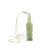 A Chinese carved celadon jade pendant: in the form of Guanyin holding a scroll, 7cm.