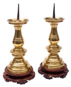 A pair of Flemish brass pricket candlesticks: the wide drip-pans with iron prickets on riveted