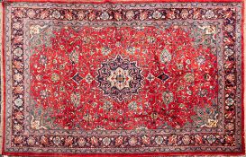 A Sarouk carpet:, the brick red field with a central indigo circular pole medallion,