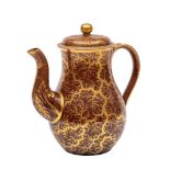 A Rockingham treacle-glazed earthenware baluster teapot and cover: decorated in gilt with a