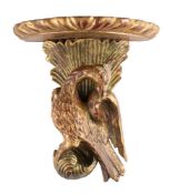 An early 19th century style giltwood wall bracket: the semi-round shelf supported by an exotic bird