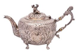 A chinoiserie design silver teapot, unmarked: bears crest and armorial, of circular outline,