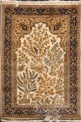 A Hereke silk prayer mat:, the ivory mihrab with a garden design of animals and birds amidst trees,
