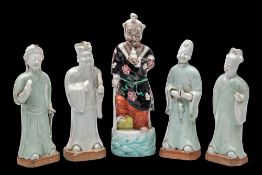 A set of four Chinese celadon glazed figures of Immortals and one other: the bases unglazed,