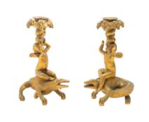 A pair of gilt metal figural candle holders: the grape festooned sconces supported by cherubs