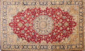A Qum part silk carpet:, the red cartouche field with a central indigo,