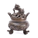 A Japanese bronze koro and cover: the pierced shallow domed cover surmounted with a dragon,