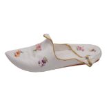 A Meissen porcelain model of a slipper: painted with scattered floral sprigs and orange heel within