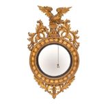 A Regency carved and giltwood framed convex wall mirror, circa 1815,