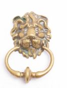 A late Victorian/Edwardian brass lion's mask door knocker: with knopped bow, 16cm high.