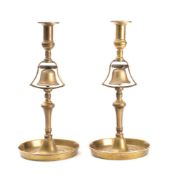 A pair of 19th century brass tavern service candlesticks: the plain sconces over a lever operated