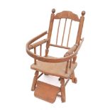 A child's beechwood elbow chair: the back with shaped top rail and spindle uprights,