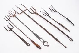 A collection of four three pronged toasting forks: of various designs.