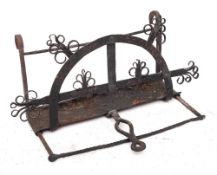 A wrought iron adjustable bar-grate toaster: with fat catcher, having scroll decoration, 49cm wide,