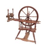 A 19th Century beechwood spinning wheel: with turned spindle spokes,