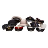 A collection of various peaked caps, including RAF and RN,