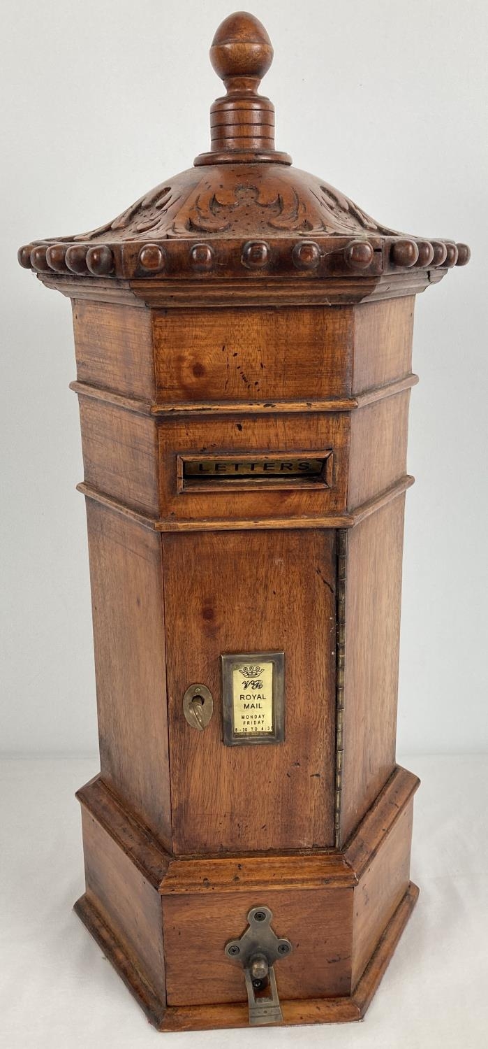 A wooden model of a replica Victorian hexagonal post box. With carved detail to top and turned