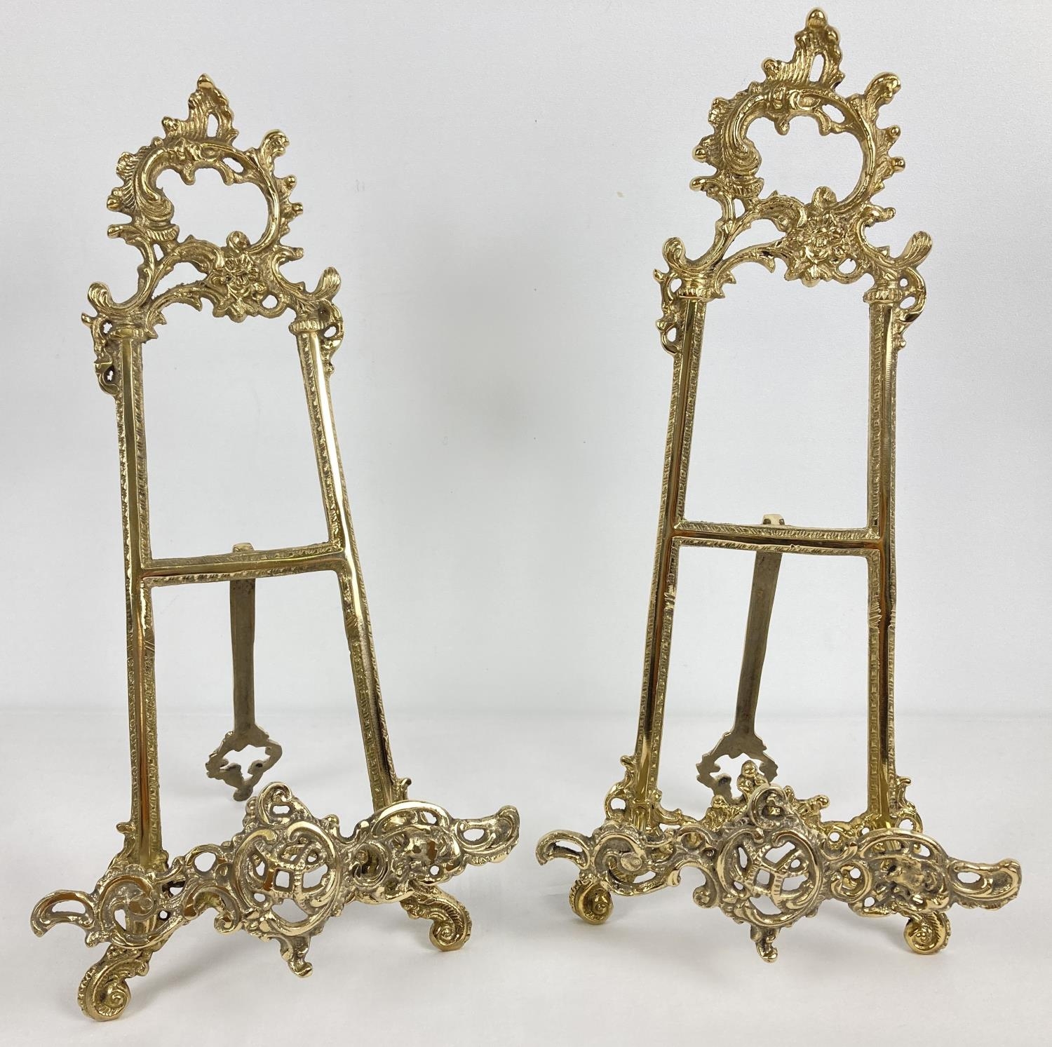 A pair of decorative brass table top easel stands with fold out supporting foot. Each approx. 41cm